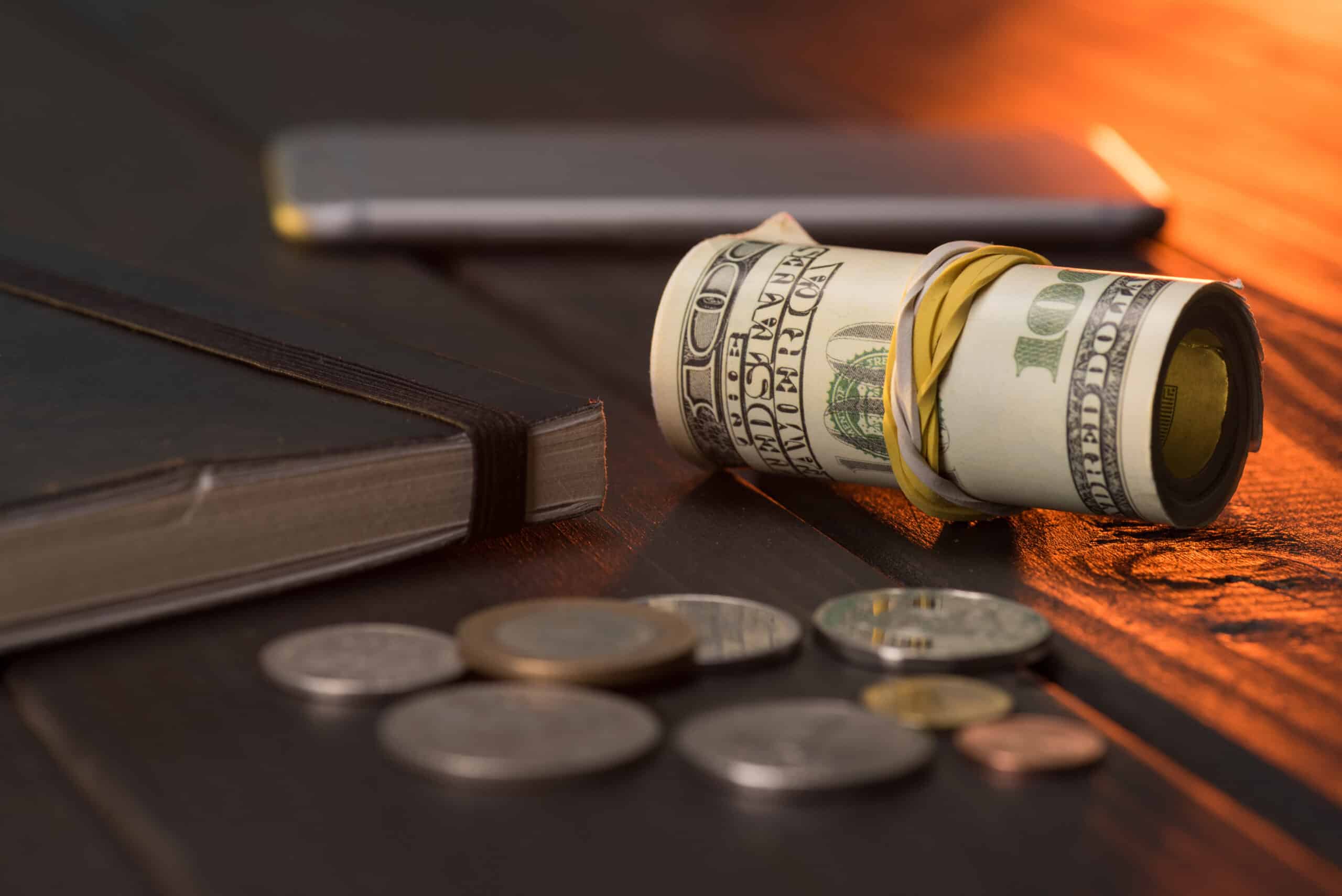 us dollars and coins with notebook and smartphone 2024 11 18 01 51 08 utc scaled